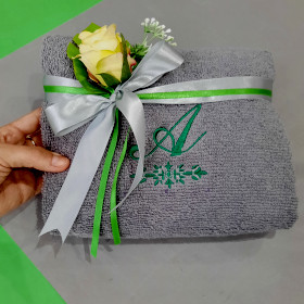 szary ręcznik z zielonym monogramem na prezent